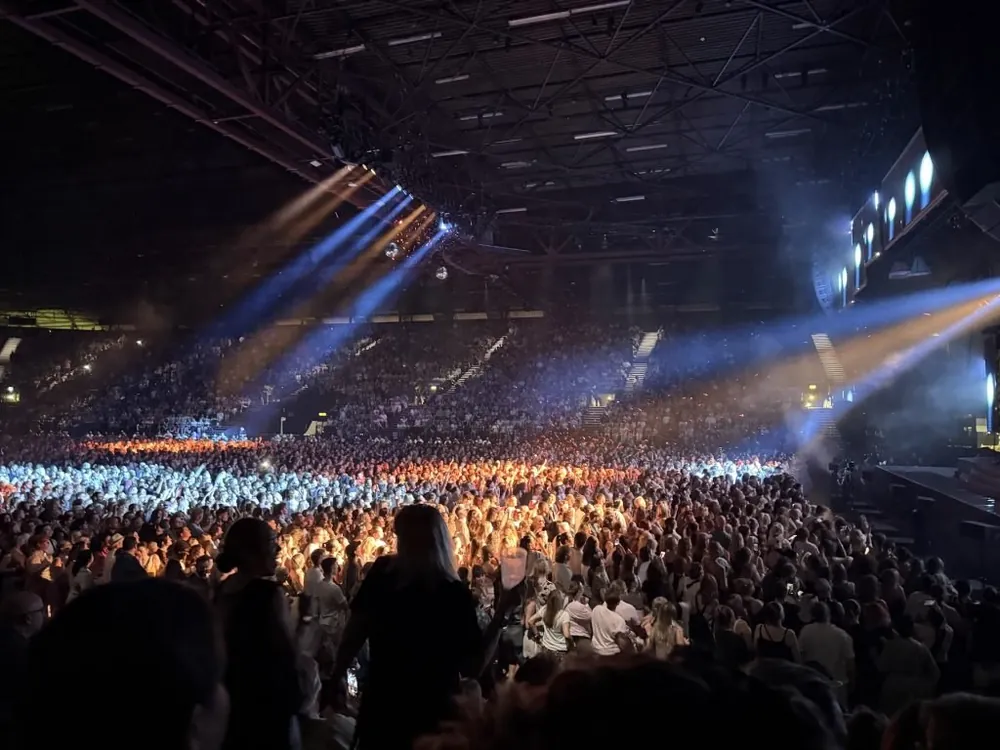 A packed arena floor under blue and gold beams at bp pulse LIVE