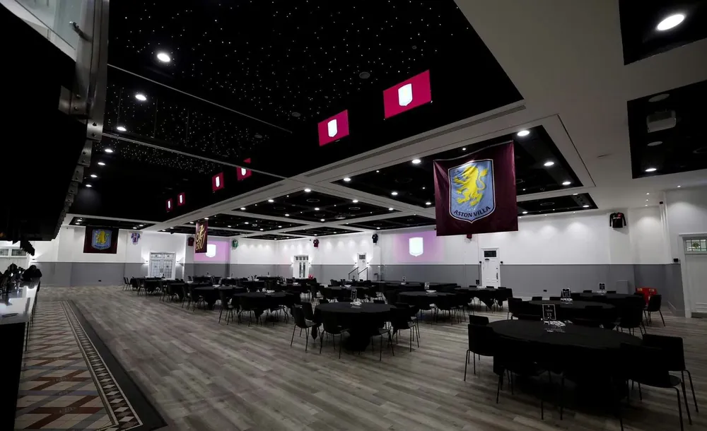 A function suite at Villa Park under a starlit ceiling, Aston Villa banners over the tables